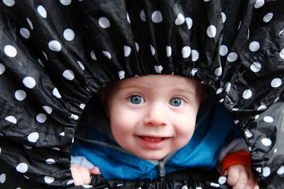 Portrait of cute baby boy in polka dots fabric