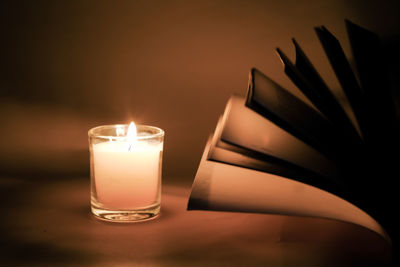 Close-up of illuminated tea light candles on table