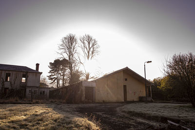 Abandoned building by trees against sky