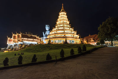Illuminated temple building against sky at night