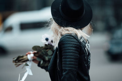 Rear view of woman wearing hat standing outdoors