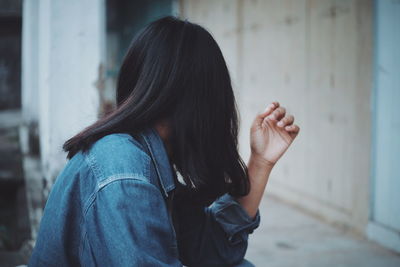 Side view of woman wearing denim jacket