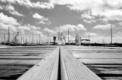 Pier on sea against cloudy sky