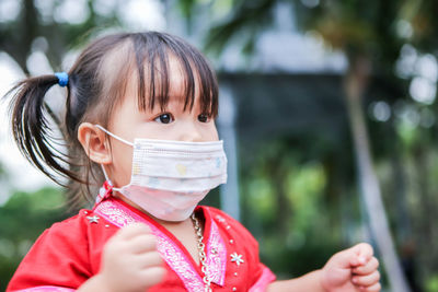 Portrait of cute girl in red dress wearing a mask