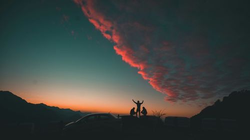 Silhouette people against sky during sunset