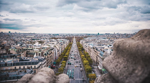 High angle view of city buildings against cloudy sky