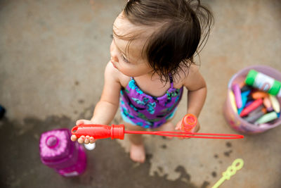 High angle view of girl playing with bubble wand