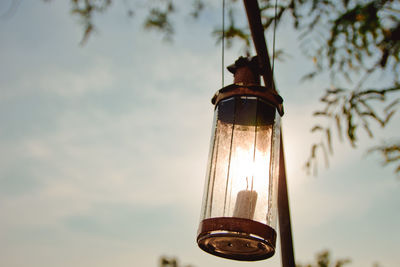 Low angle view of lantern hanging against sky during sunset