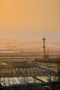 Snow covered land against sky during sunset