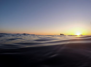 Scenic view of sea against clear sky during sunset