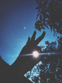 Low angle view of person hand against bright sun