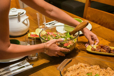 Midsection of woman having food at table