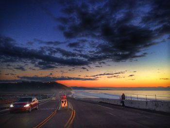 Scenic view of sea against cloudy sky during sunset