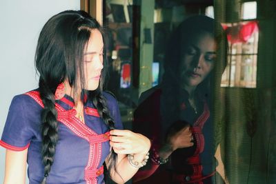 Young woman standing against wall