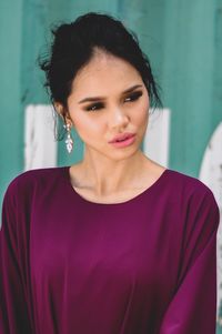 Fashionable woman standing against wall