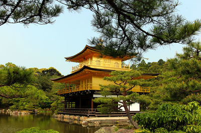 Traditional building by lake against sky