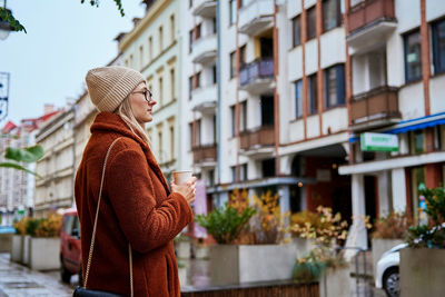 Woman at city street with coffee cup