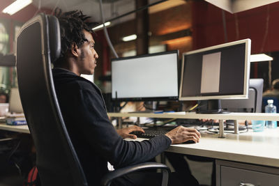 Man using computer at desk in office