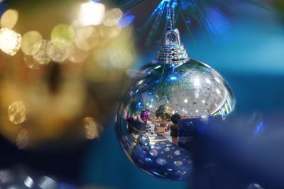 Close-up of christmas decorations hanging on glass