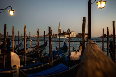 Boats moored at harbor against sky