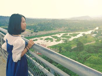 Side view of young woman looking at landscape