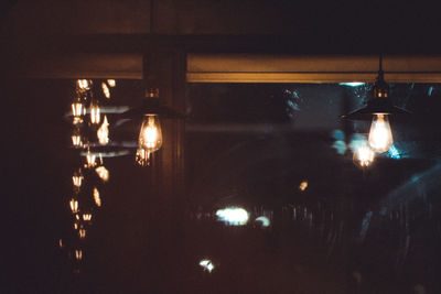 Illuminated lights hanging from ceiling in restaurant