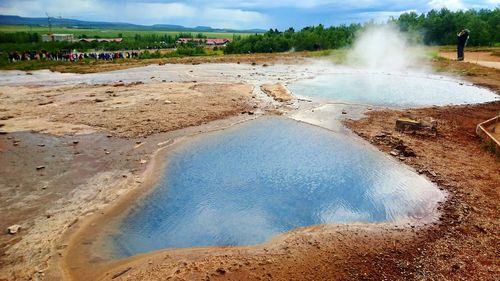 Scenic view of steam emitting from geyser
