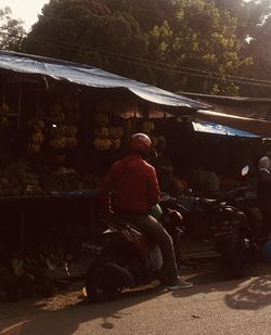 Rear view of man sitting on street market