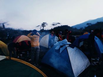 Group of people in tent against sky