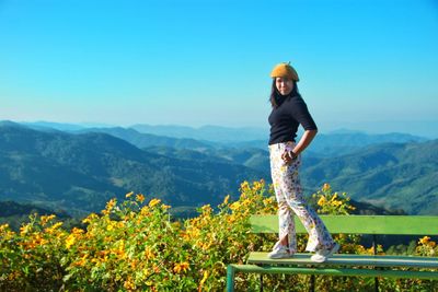 Portrait of woman standing on mountain against sky