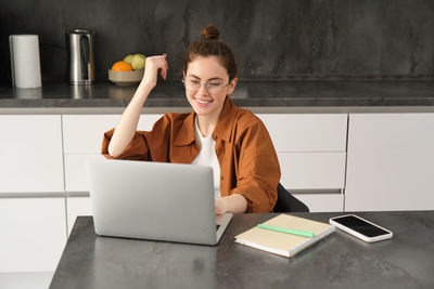 Man using digital tablet while sitting on table