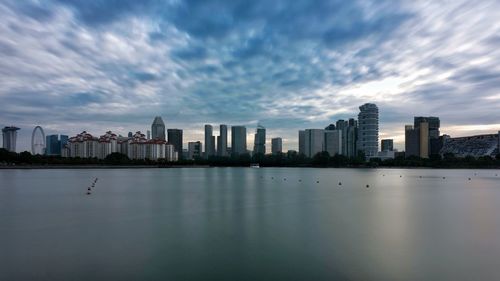 Sea and buildings in city against sky