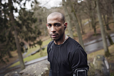 Portrait of confident male athlete standing in forest