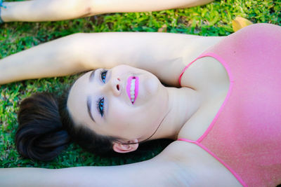 High angle view of young woman lying down on field