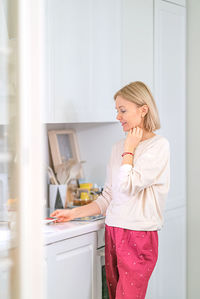 Smiling woman holding plate while standing at home