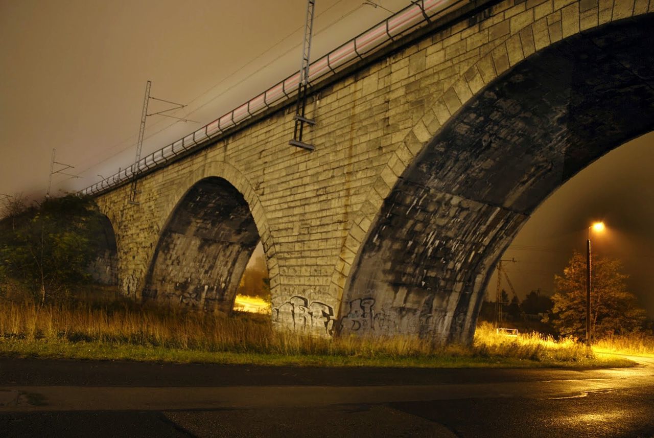 LOW ANGLE VIEW OF BRIDGE AT NIGHT