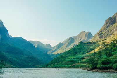 Scenic view of lake and mountains against clear sky