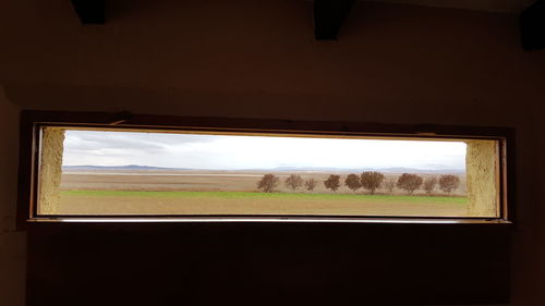 Scenic view of field seen through window