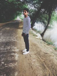 Full length portrait of young man standing on street