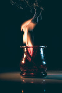 Close-up of illuminated candle against black background