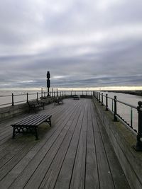 Pier on beach against sky