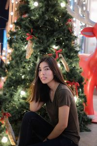 Portrait of young woman with christmas tree