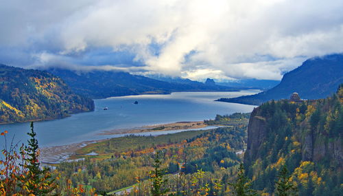 Scenic view of lake by mountains against sky