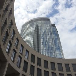 Low angle view of modern building against cloudy sky