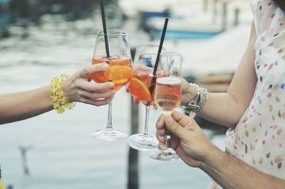 Cropped image of hands toasting up drinks