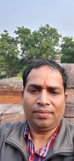 Portrait of young man against trees