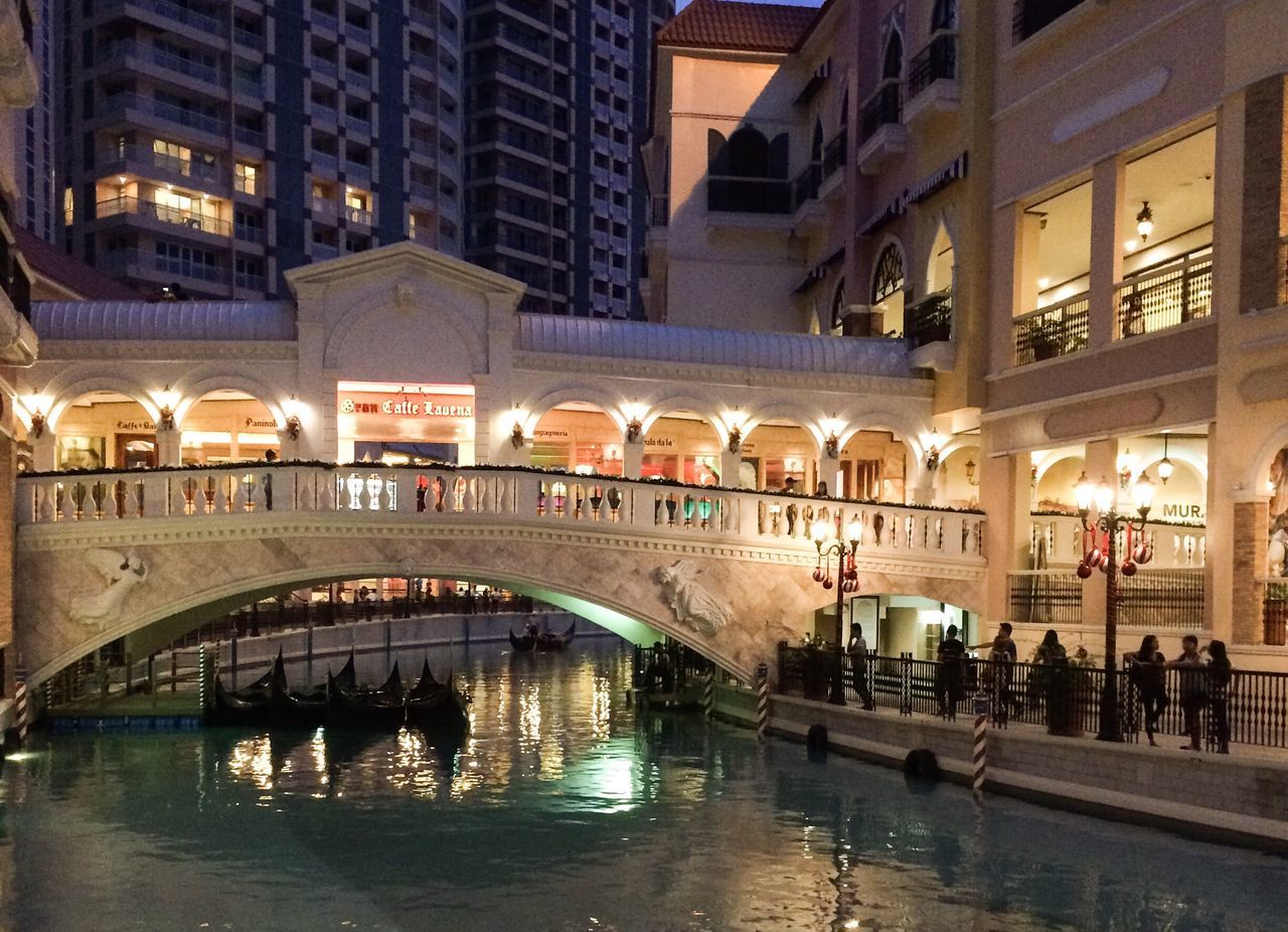 HIGH ANGLE VIEW OF ILLUMINATED FOOTBRIDGE OVER CANAL