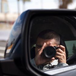 Man photographing by camera in car
