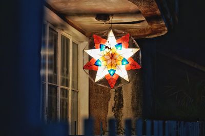 Illuminated lantern hanging outside house at night
