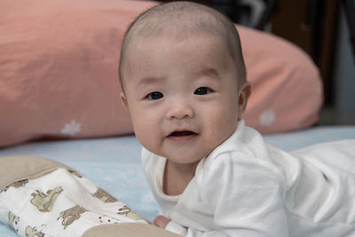 Portrait of cute baby lying on bed